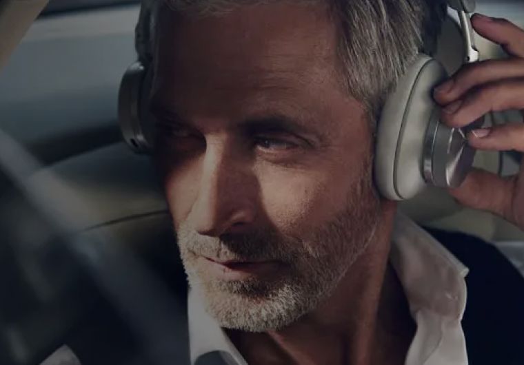 A background image for Bang & Olufsen of a man wearing headphones